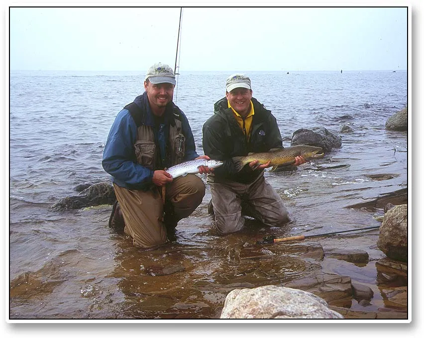 Two different fish - Kasper and Steve with each their representative of the variations within sea trout: Kasper's fish is a socalled Greenlander - a small fish that has not spawned yet but fed all winter - while Steve's is an extremely dark, almost brown trout like, male that has spawned and is still reviving from the feat. Both fish were released after the picture was taken.